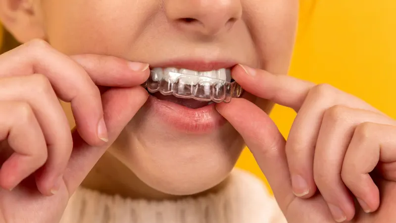 Dentist reviewing a dental implant model with a patient during a follow-up appointment