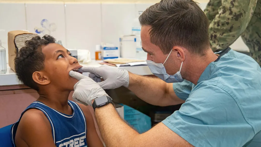 Dentist examining a young boy's teeth during a pediatric dental checkup