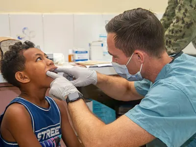 Dentist examining a young boy's teeth during a pediatric dental checkup